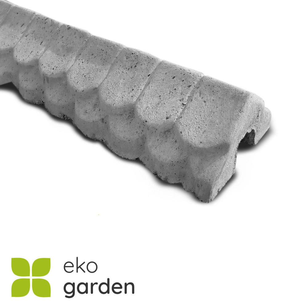 42 | Nahaufnahme eines dreieckigen Betonzaun-Elements. Die graue Betonoberfläche zeigt eine raue Textur mit sichtbaren Poren. Das Element hat eine wellenförmige Struktur mit sieben abgerundeten Erhebungen, die gleichmäßig verteilt sind. Die Form erinnert an eine stilisierte Zahnreihe oder Wellenmuster.