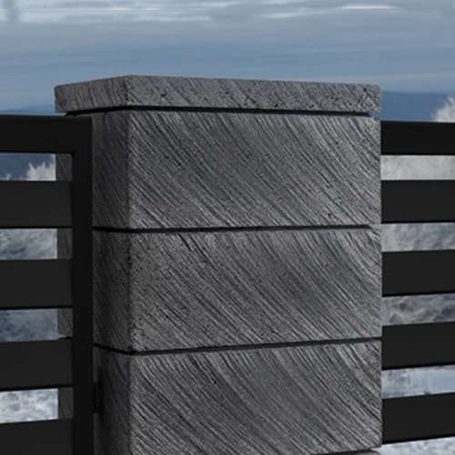 Grauer Betonpfeiler mit diagonaler Strukturierung, Teil eines modernen Gartenzauns vor bewölktem Himmel